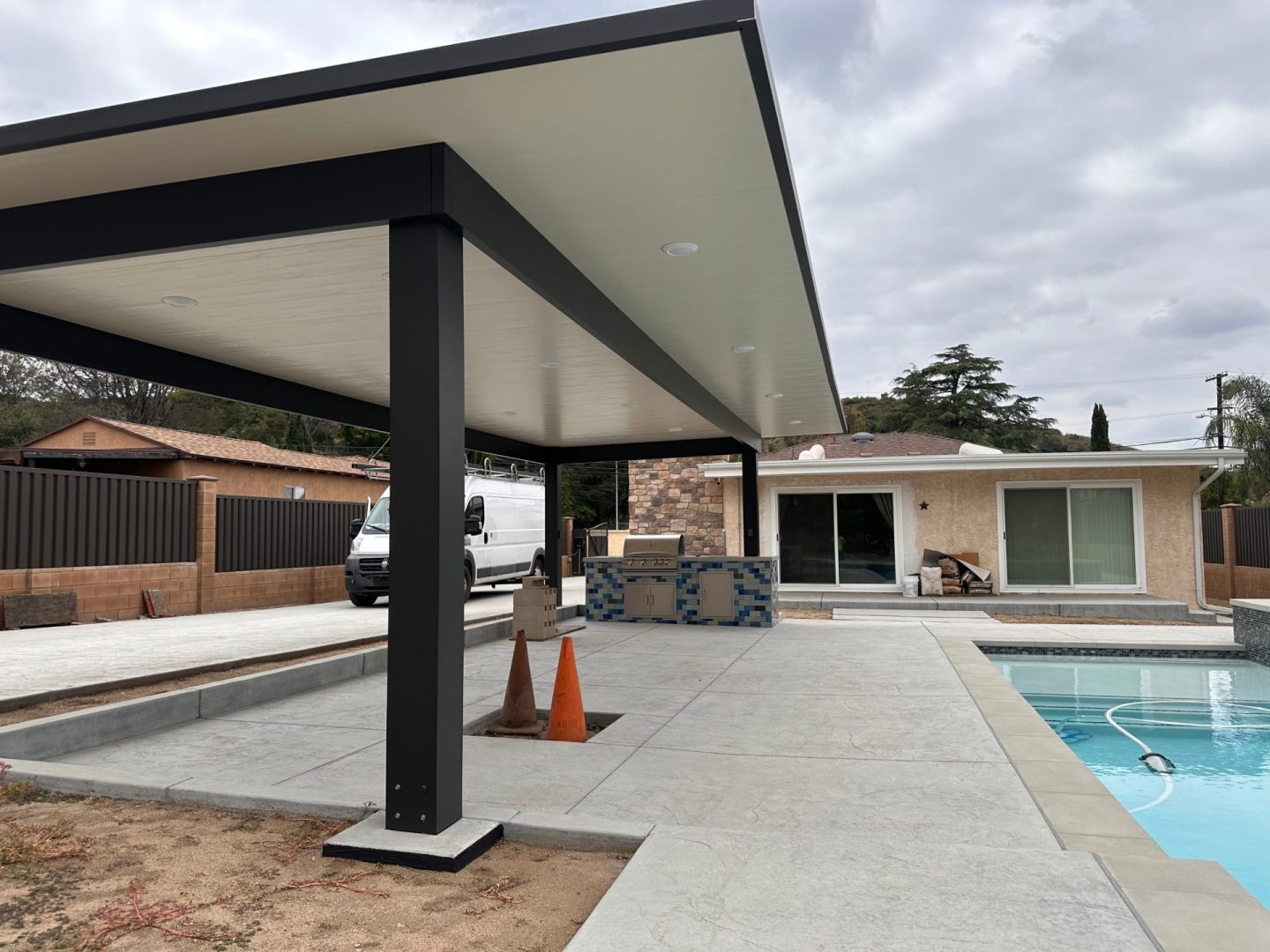 A tranquil swimming pool with a spacious covered patio, ideal for enjoying the outdoors while staying protected from the sun.